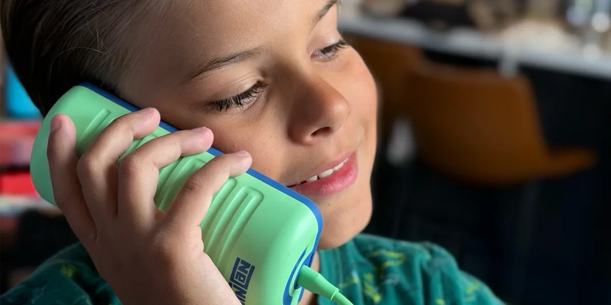Our son mid-call on the Tin Can, the mint-green handset to his ear