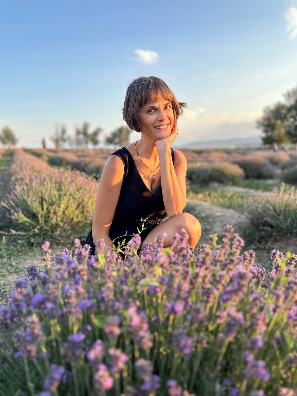 Soshanna kneeling in a lavender field at golden hour
